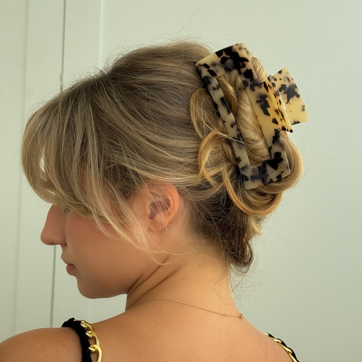 Close-up of a tortoise shell acetate XL claw clip holding a full blonde updo