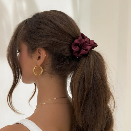 An organic premium silk scrunchie in burgundy available at HoneyLux.