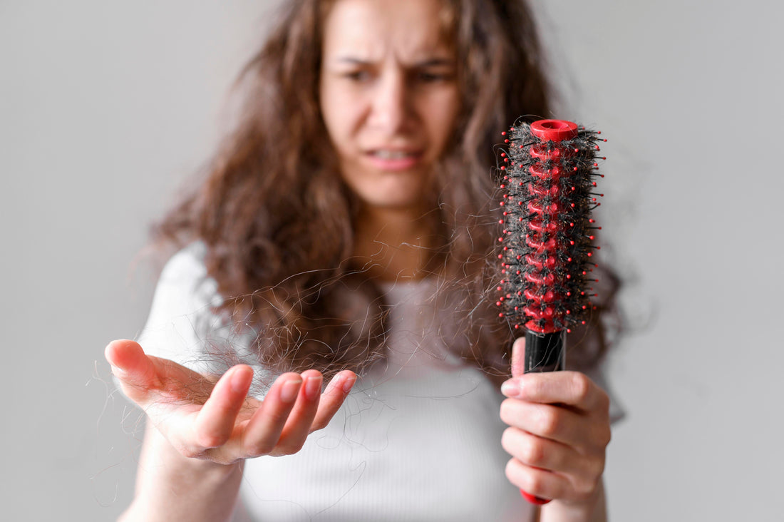 Woman looking at the hair on her hands that broke out while combing.